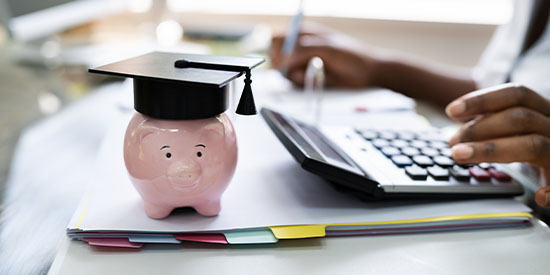 Piggy bank wearing graduation cap.