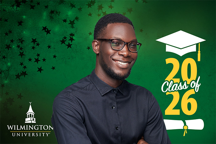 A monitor background image of a WilmU graduate