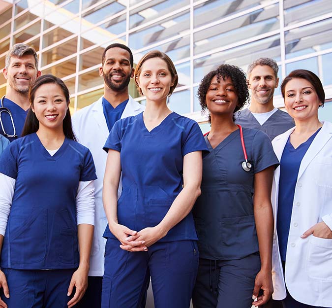 Group of nurses dressed in their uniforms smiling at the camera